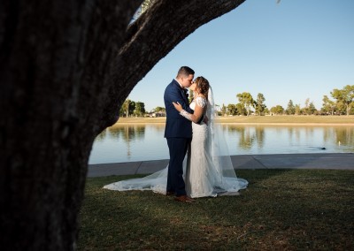 Villa Tuscana Reception Hall in mesa showing nearby park area showing bride and groom under tree by lake