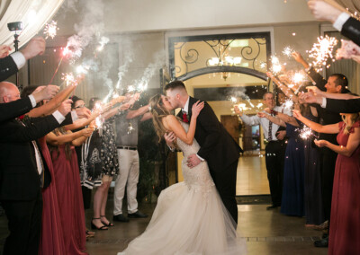 Villa Tuscana Reception Hall in mesa showing bride and groom kissing while leaving reception